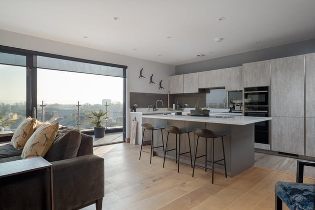 The kitchen boasts handle-less furniture, deep drawers and glass splashbacks. A contrasting island, with storage on both sides, is as perfect for perching at over breakfast as for chatting to the cook with a pre-dinner glass of wine