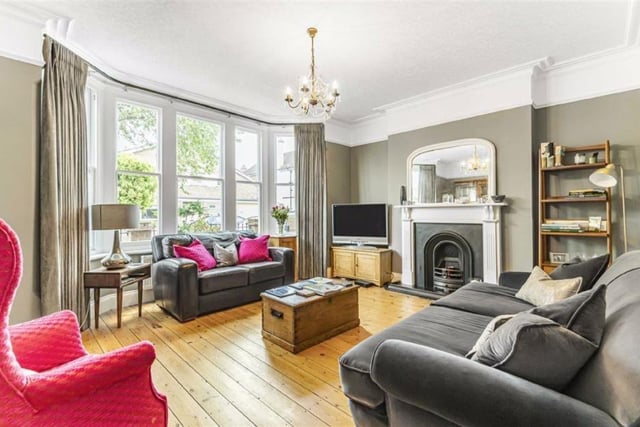 The front living room retains a cosy feel and has a large sash bay window, period open fireplace and stripped wood flooring