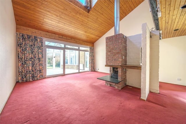 The sitting room has a feature brick fireplace with an inset gas fire and a double height pitched ceiling. Sliding doors lead to the conservatory