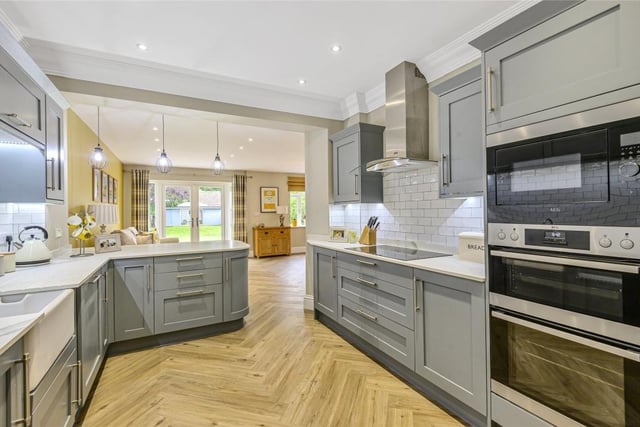 The kitchen area has been refitted in a range of Shaker-style units with complementary work surfaces incorporating a sink and drainer. Integrated appliances include an electric oven, an induction hob with extractor over, a microwave, dishwasher, wine chiller and two larder fridge/freezers