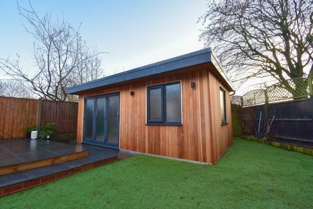 The modern timber cladded outbuilding in the back garden boasts bi-fold doors