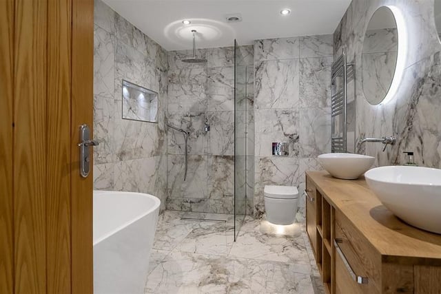 The fully tiled bathroom, with freestanding bath, rainfall shower and double sinks has fantastic lighting making this room feel luxurious and cosy