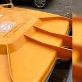An orange wheelie bin