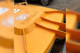 An orange wheelie bin