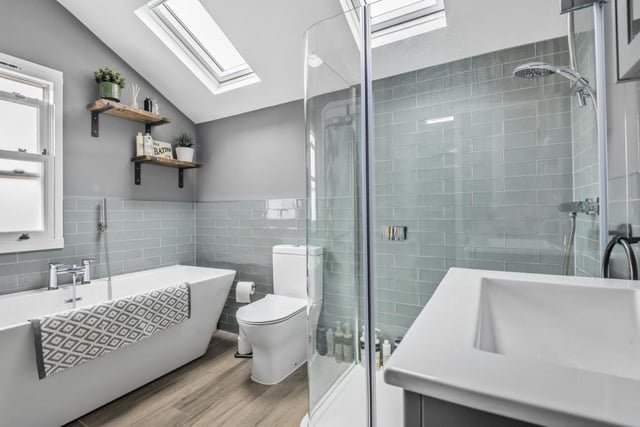 The spacious bathroom features a modern suite including a separate shower cubicle