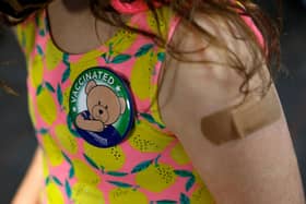 A child wears a 'vaccinated' badge (Photo by JEFF KOWALSKY/AFP via Getty Images)