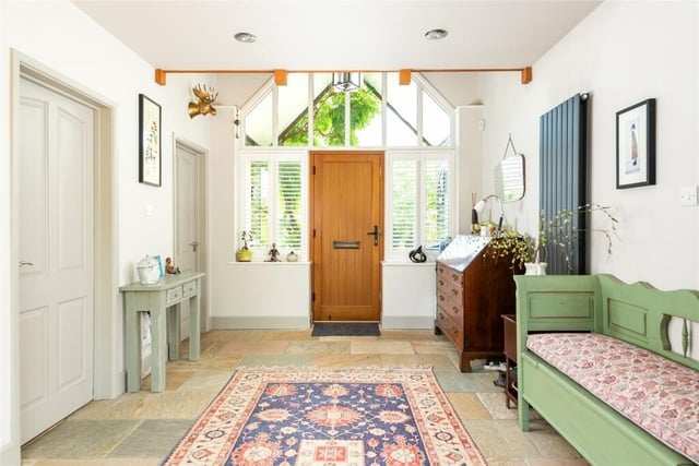 The spacious hallway has a staircase to a mezzanine galleried family room, and an exposed flagstone floor which continues into the kitchen and sitting room
