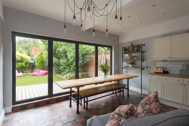 The room measures 14ft 8in by 24ft 5in and the dining part features bifold doors to extend the kitchen outside to an area watched over by a fabulous fig tree