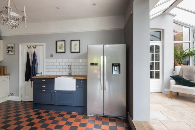 From the garden room, you enter the open-plan kitchen/dining room, complete with chequered red and black quarry tiles