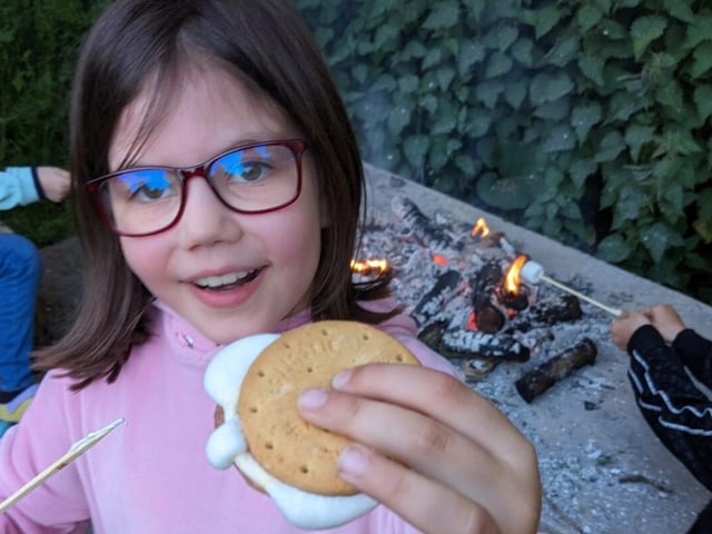 A Cub Scout holds a s'more