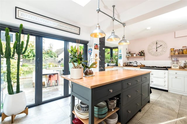 The kitchen area has a bay window, a lantern skylight and bi-fold doors to the rear garden. There are two-tone Shaker style cabinets, a central island, hardwood work surfaces, and space for a range cooker