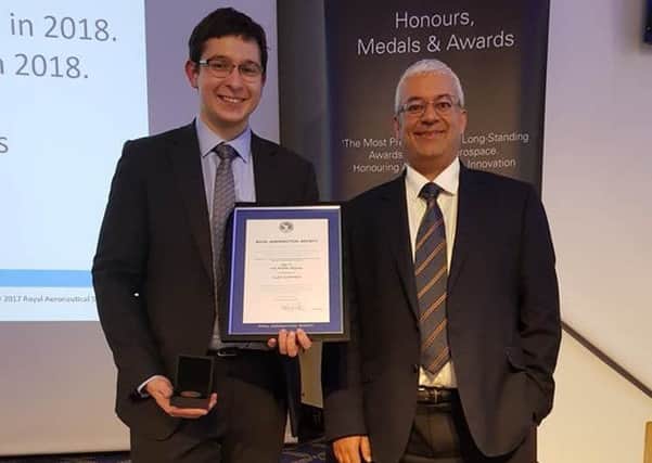 Alex Godfrey with his Royal Aeronautical Society award, accompanied by head of engineering Christopher Tree.
