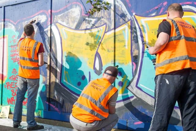 Offenders removing grafitti as part of the community payback scheme. Picture: Robin Jones. EMN-180105-124506001