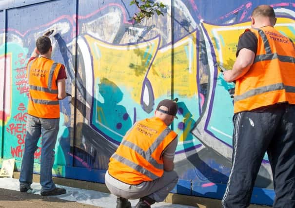 Offenders removing grafitti as part of the community payback scheme. Picture: Robin Jones. EMN-180105-124506001