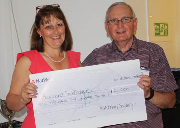 Sarah Broughton, Project Manager at Bedford Foodbank, receiving a cheque for Â£6,500 from Mike Chappell, Chairman of St Philip & St James Golf Society