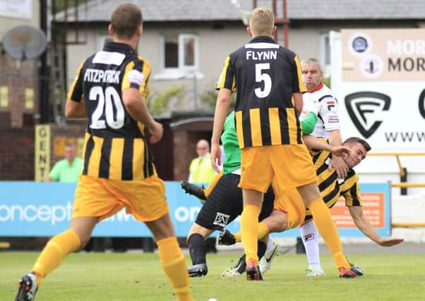 Steve McNulty tangles with Southport defender Luke George