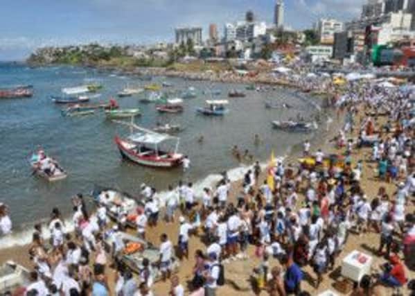 Local people taking part in celebration of the sea goddess Yemanja, in which gifts are placed in a boat for fisherman to take out to sea to be left for Yemanja. Pic: Rita Barreto/Visit Brazil Travel Association.