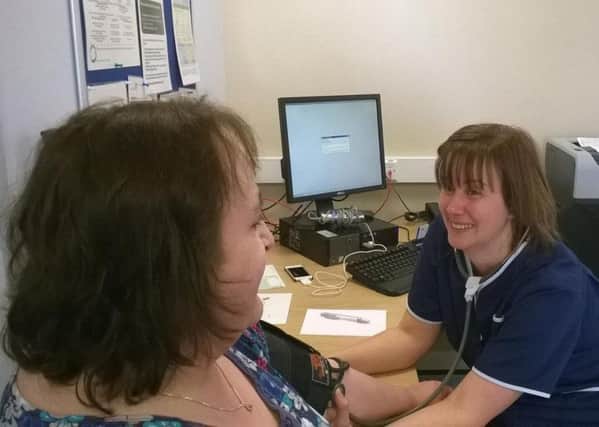 Susan Dayer having her blood pressure checked by diabetes specialist nurse Abbi Bown
