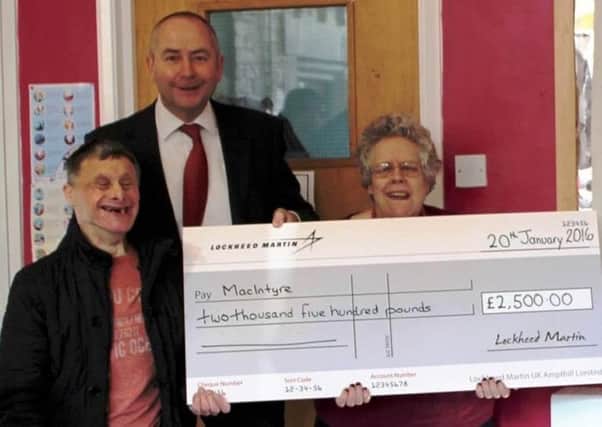 Lockheed Martin UK director of operations Graham Harraway presents a cheque for Â£2,500 to MacIntyre in Ampthill.