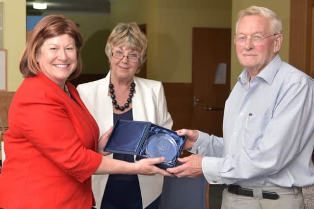 Lord-Lieutenant Helen Nellis  and Val Woods  present a retirement gift to John Chasey, one of the 50-strong team of volunteers, who has been involved with delivering oxygen therapy to people with MS for over 20 years.